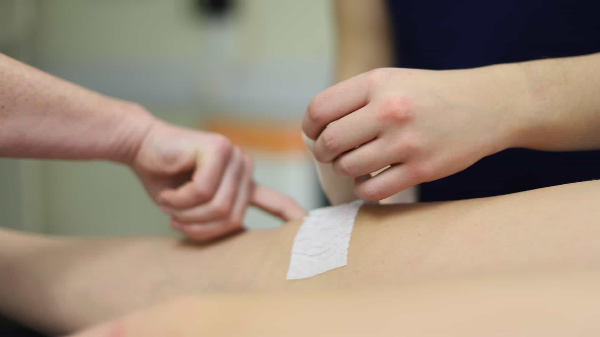 23 Sports Therapy 7 Two people treating someone's knee in a clinic