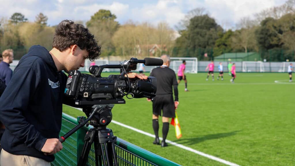 sports media student filming a football match