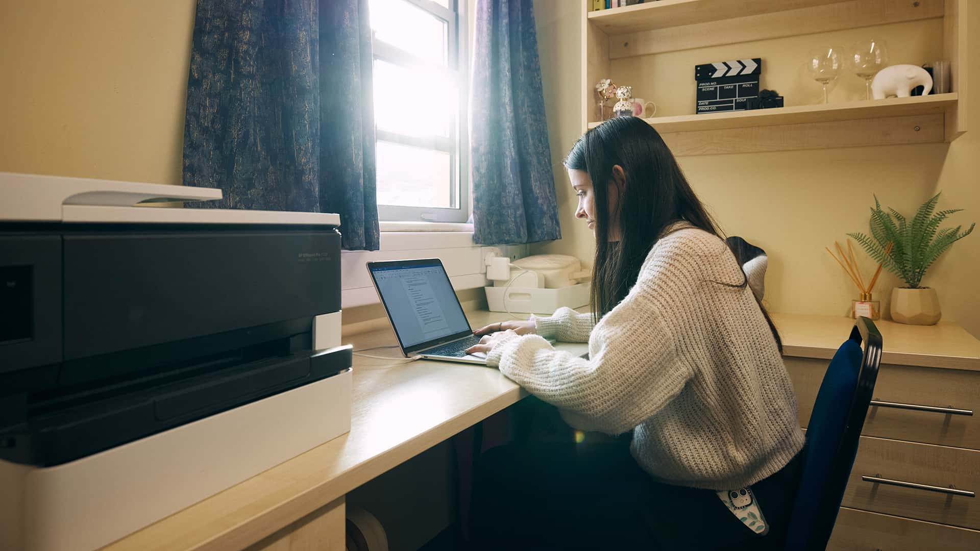 A student working at a desk in their accommodation room