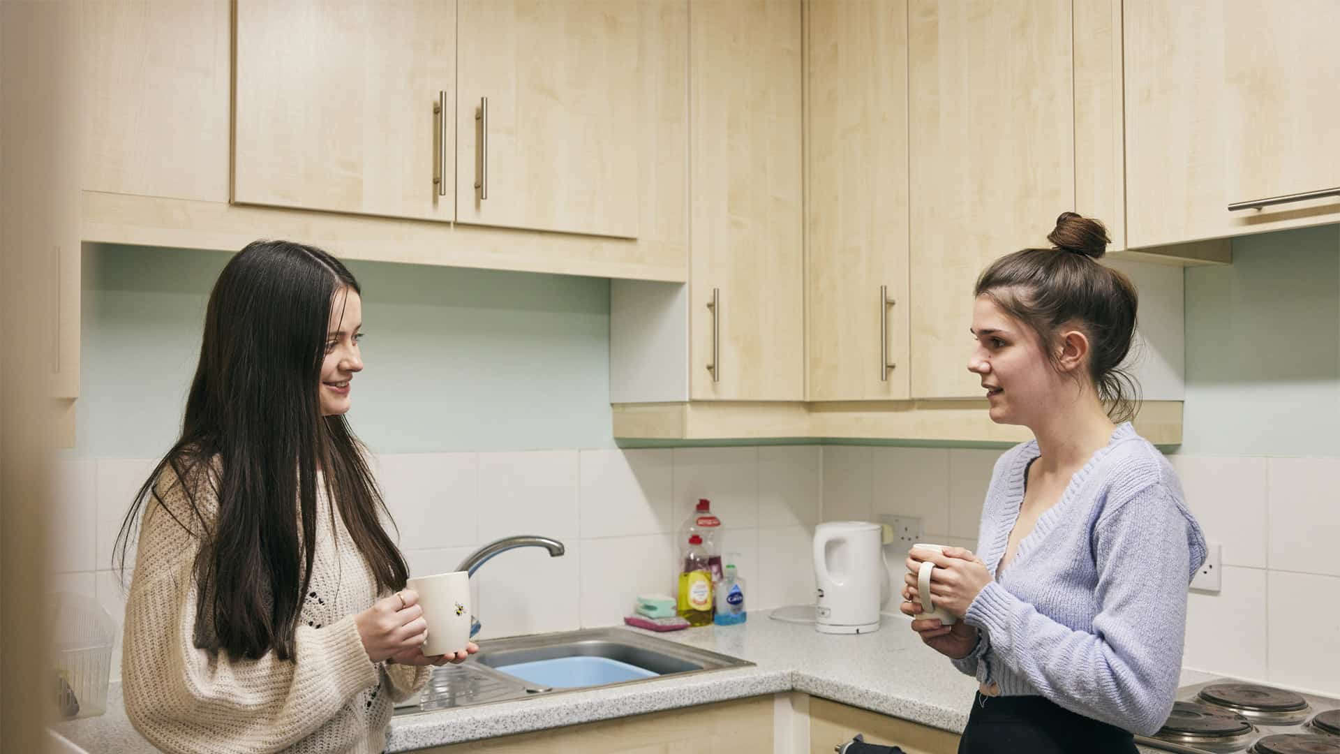 Two students having a cup of tea in accommodation kitchen