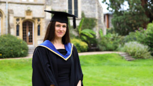 Sophie in graduation attire outside of cloisters