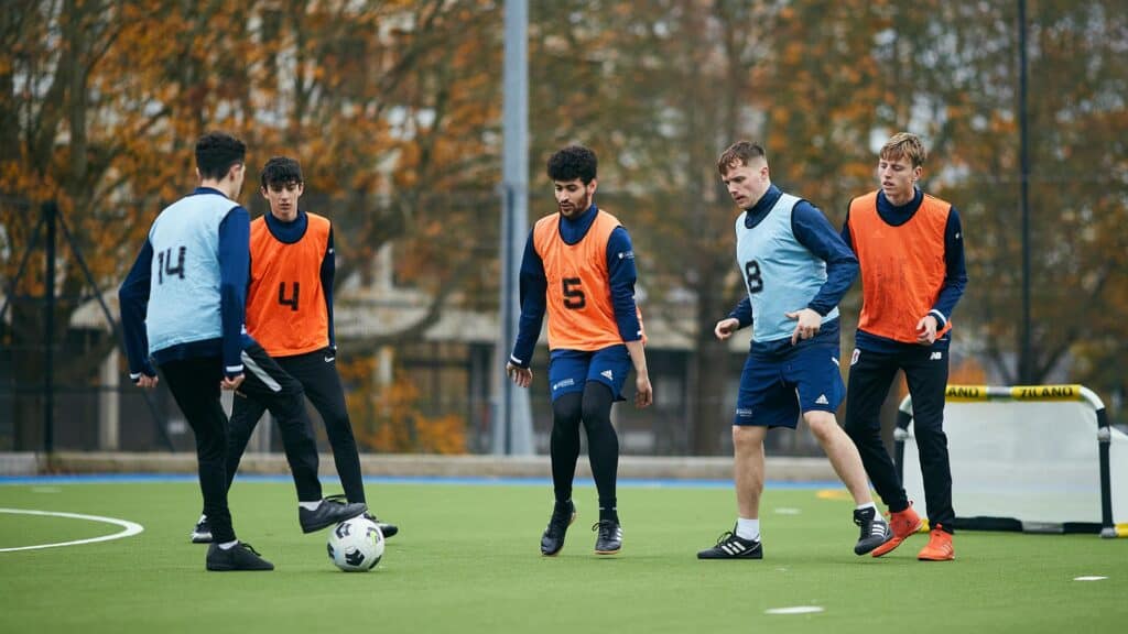 Football students playing on the astro