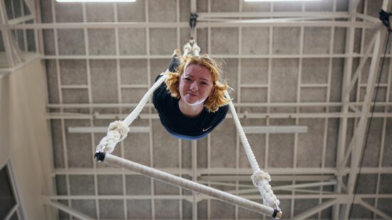 Dance aerial student hanging from a trapeze