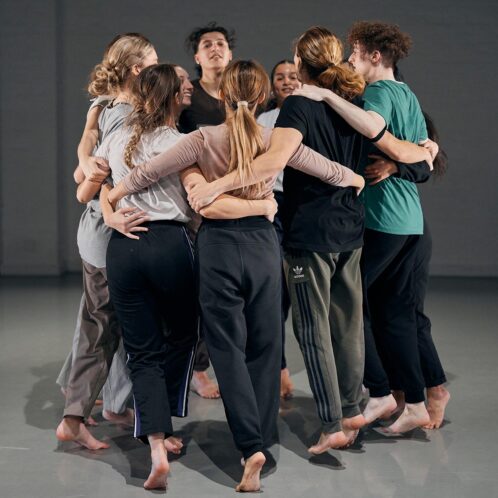 Dance students hugging in a circle