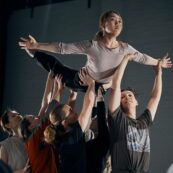 dance students rehearsing a routine holding a girl in the air