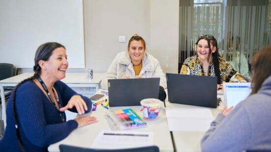 education lecturer sat with students in class