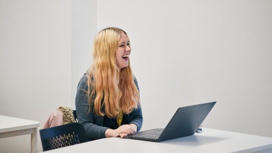 Student smiling in their Media Class