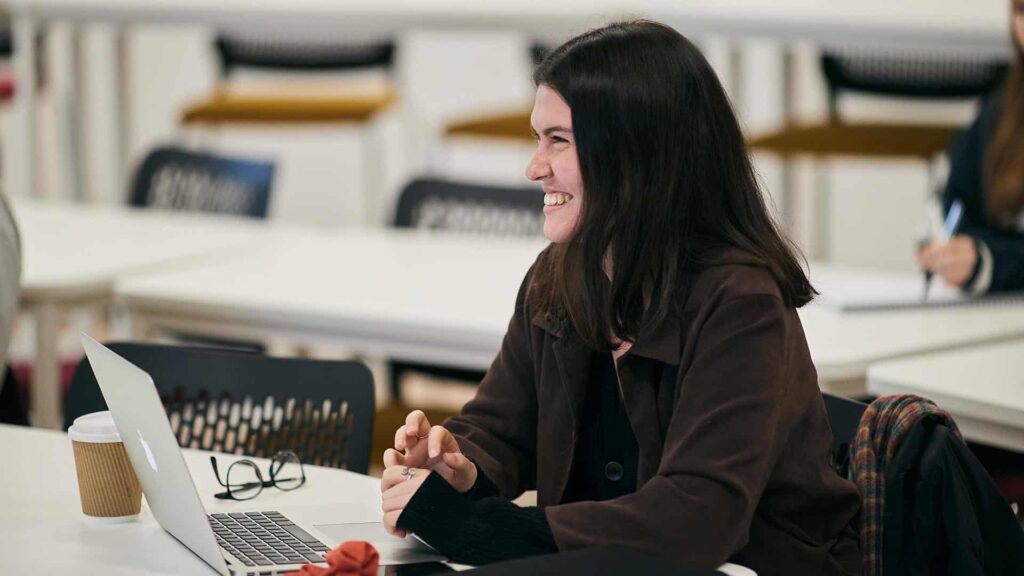 Student smiling in their media class