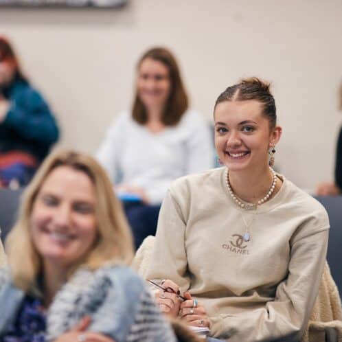 students sat in a lecture smiling