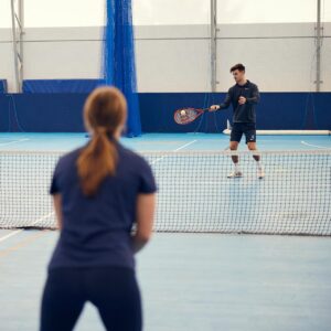 Male and Female student playing tennis