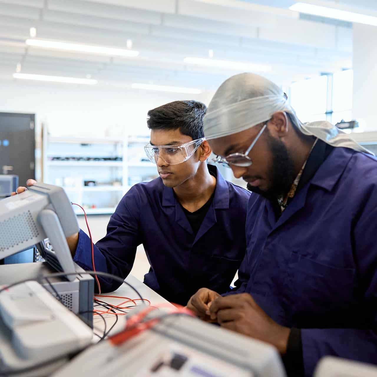 Engineering students using workshop equipment