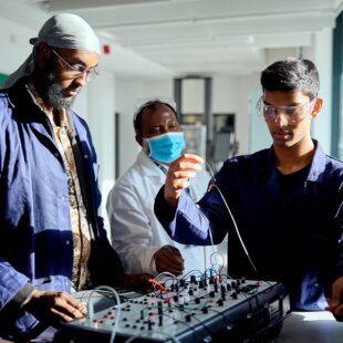 Engineering students working together with a teachers help
