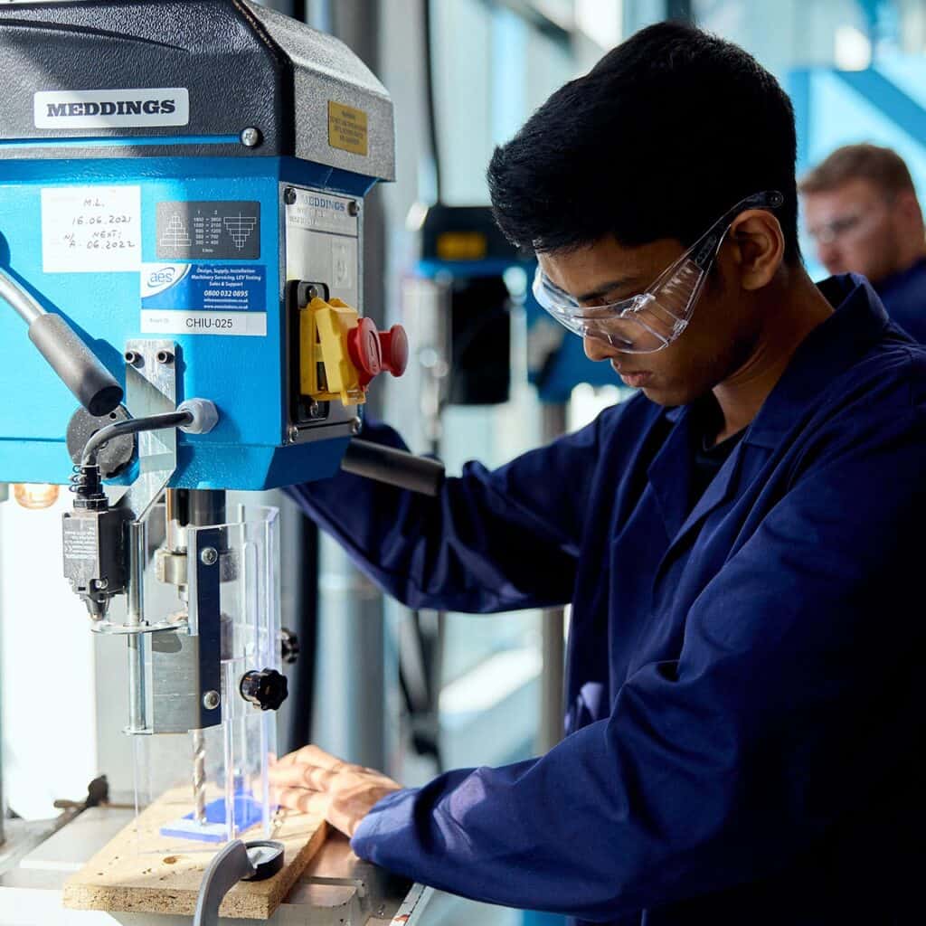 Engineering students using equipment in the workshop