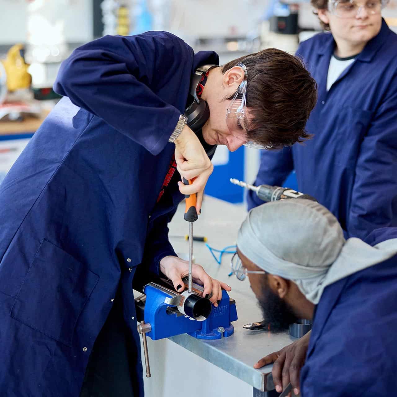 Engineering students using equipment in the workshop