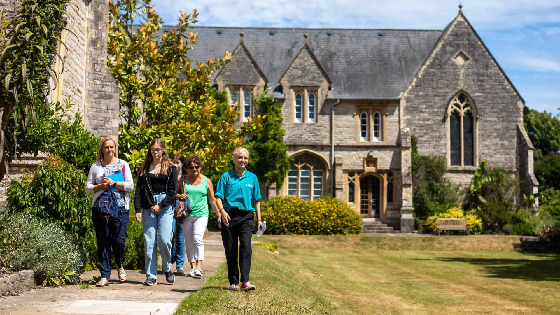 Student ambassador taking visitors on a tour through Cloisters lawn