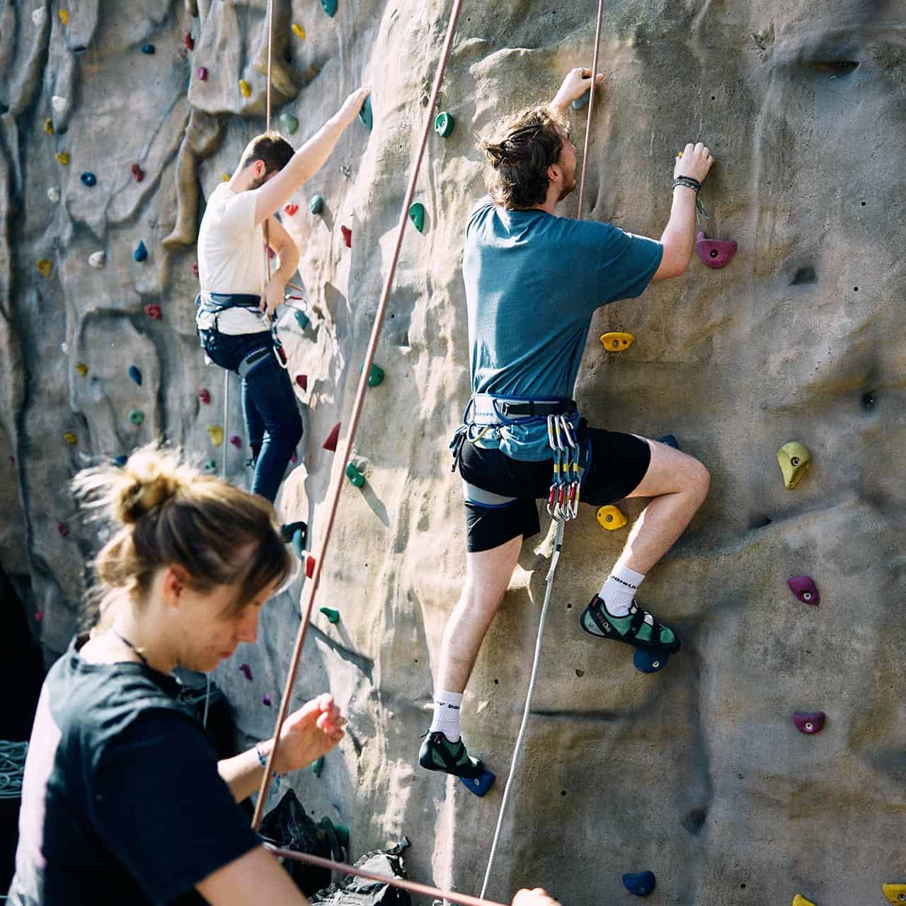 Two students climbing rock climbing wall