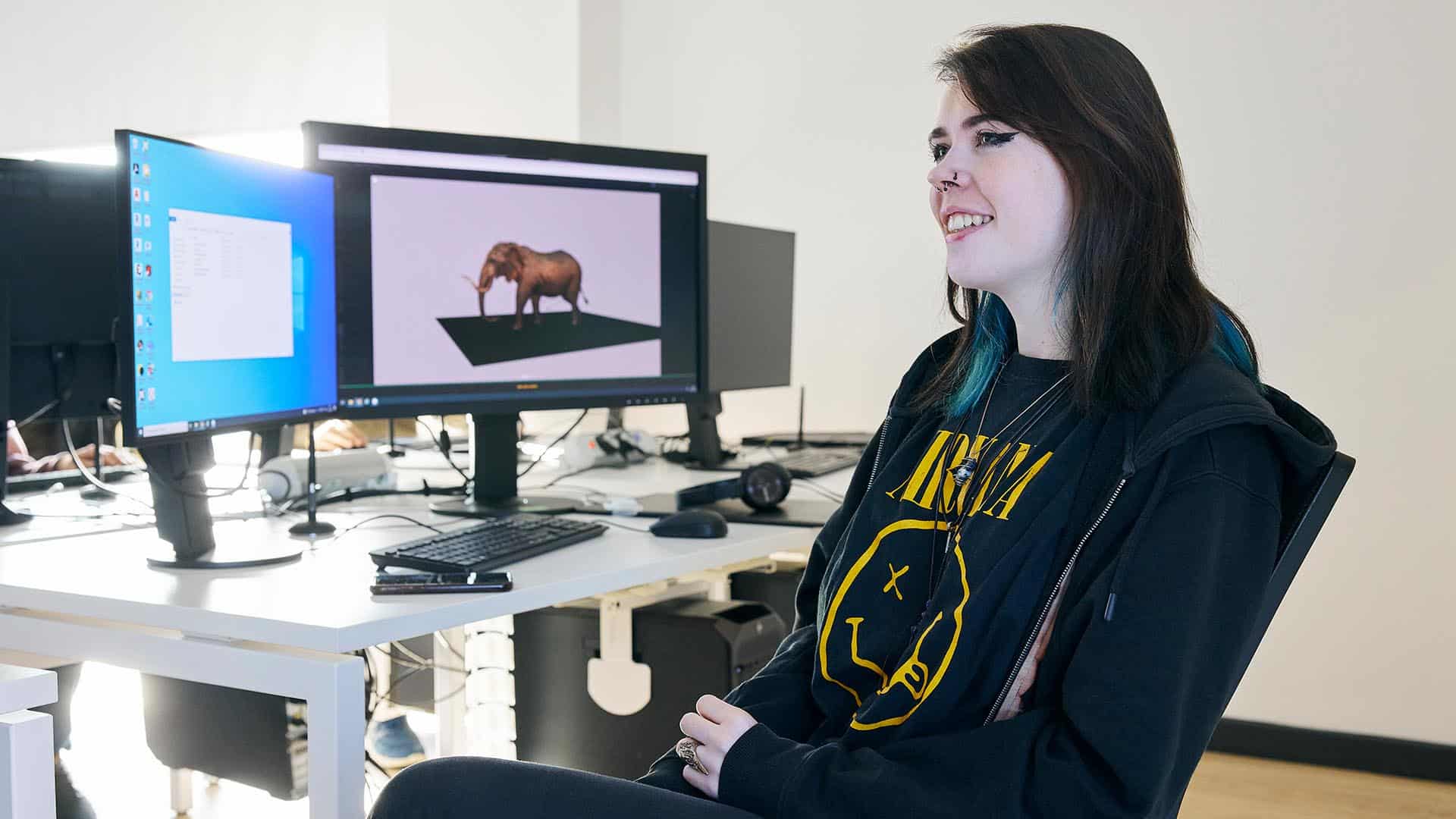 3D Animation student sat watching their lecturer with a 3D elephant on their computer screen