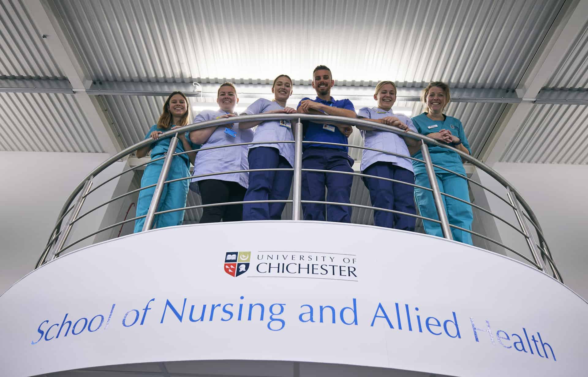 Nursing lecturers standing on balcony in Nursing School building