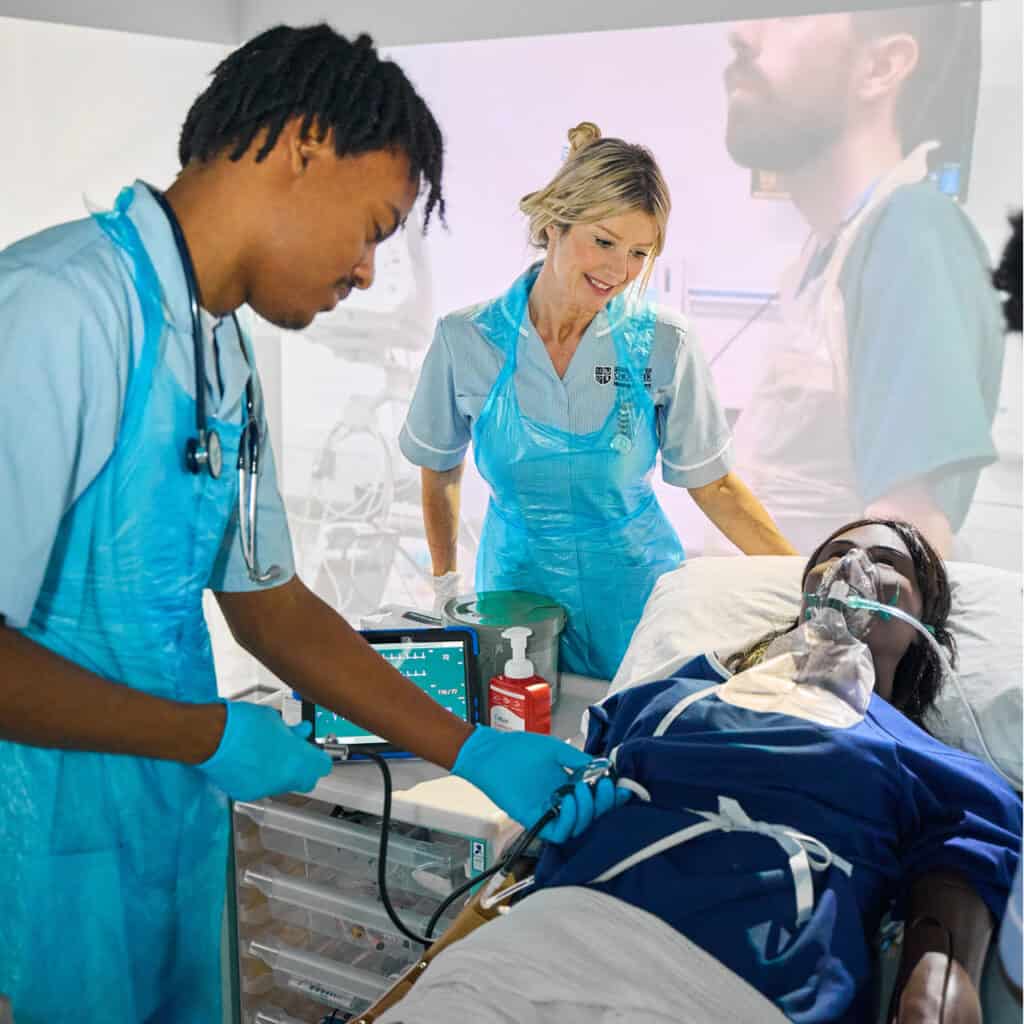 Nursing students in the immersive simulation room working with a responsive robot