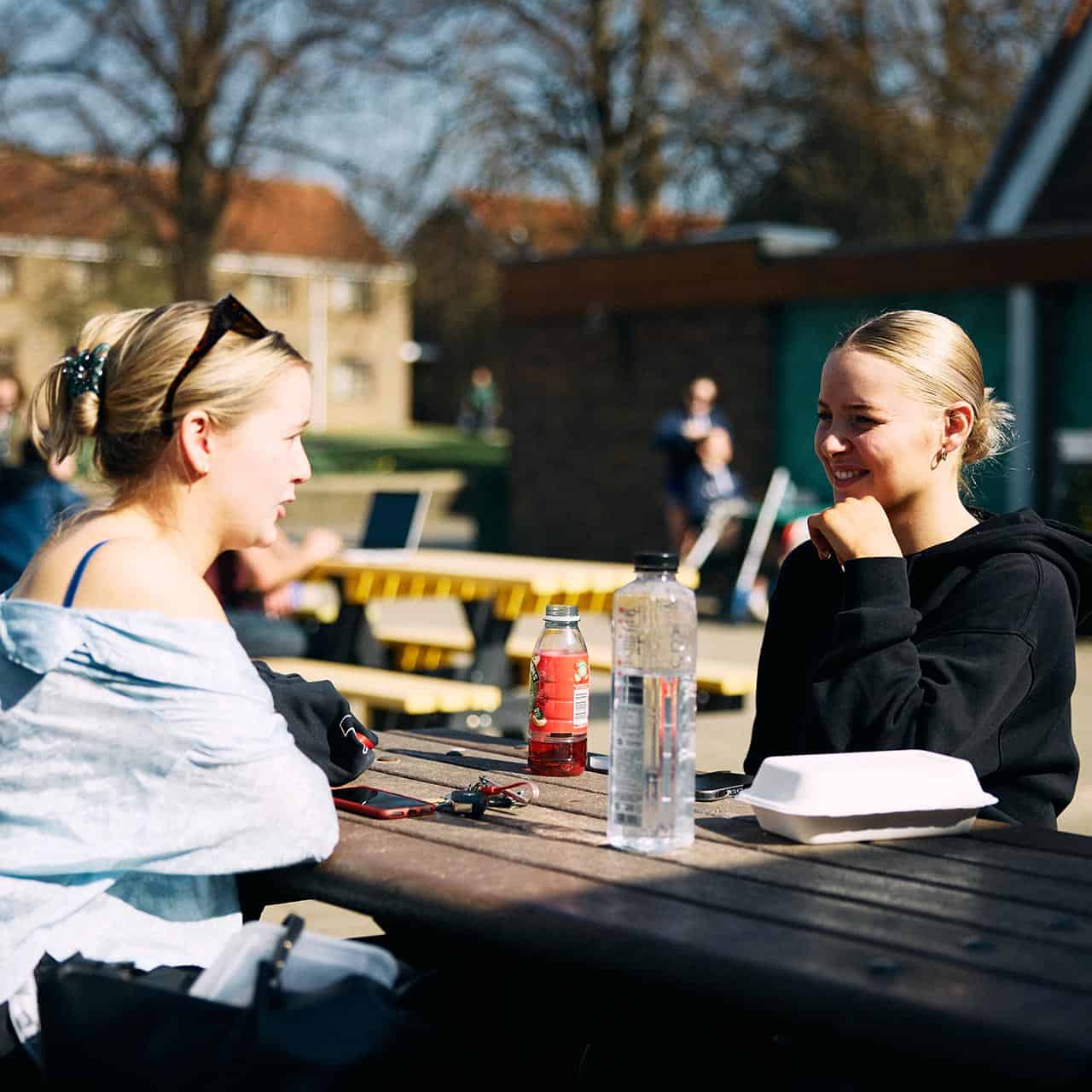 students chatting on a table outside