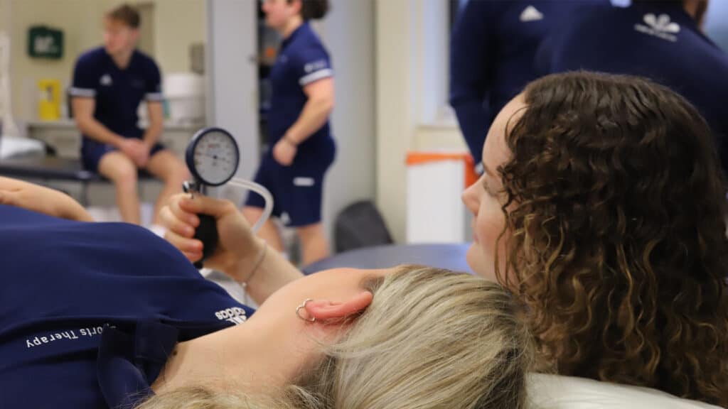 Sports therapy student working with equipment