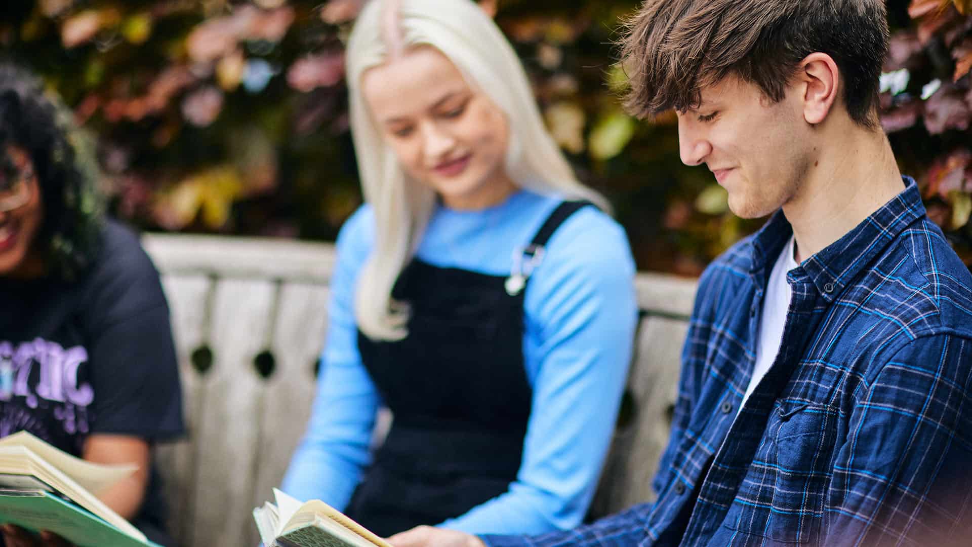 students on a bench reading