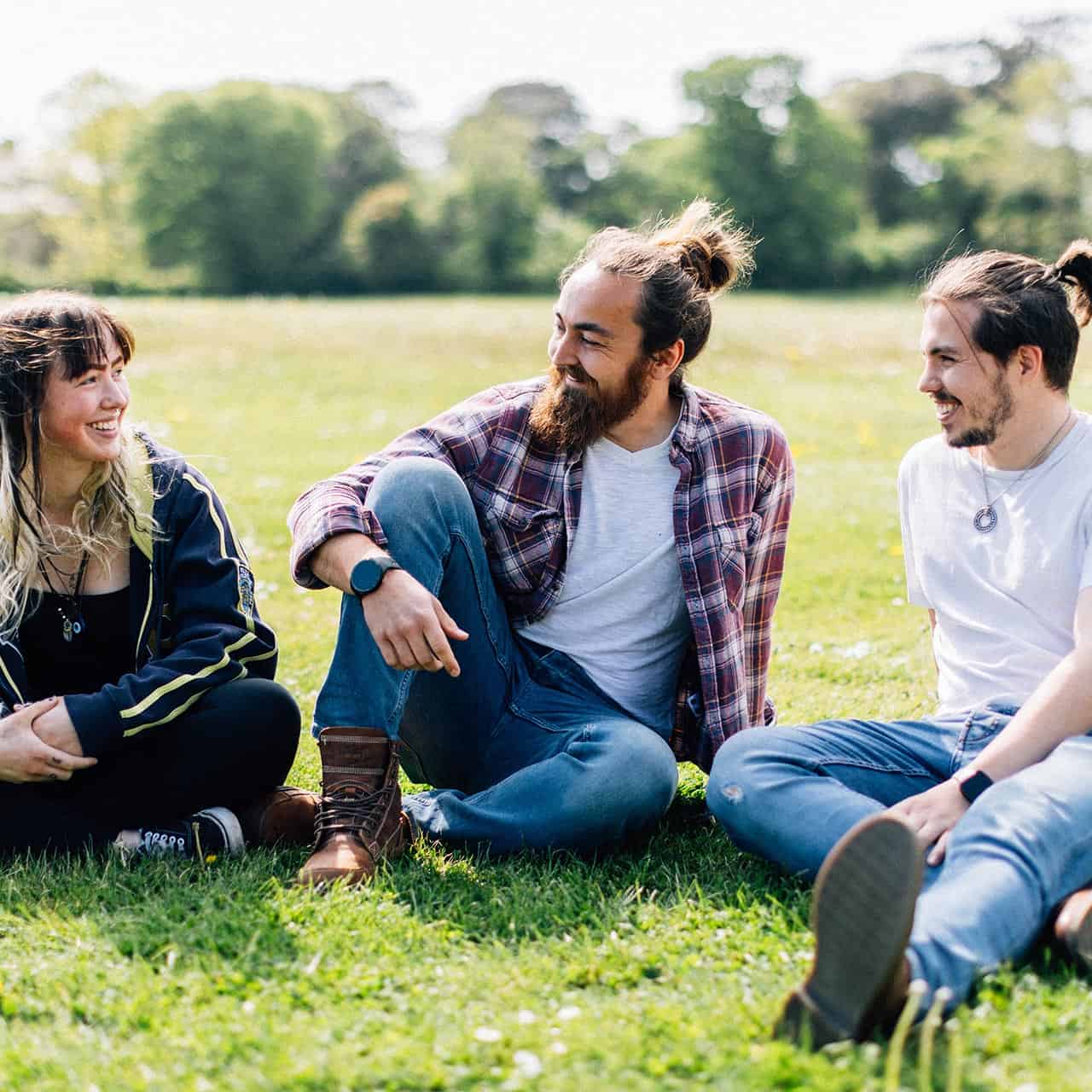 mature students sat outside on grass