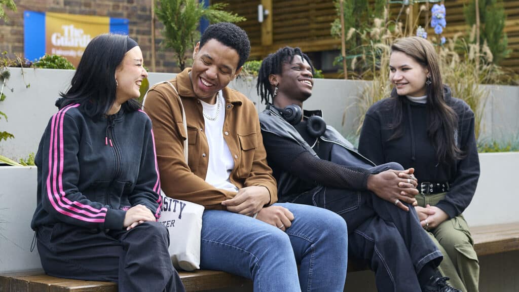 students sat talking in the campus shop courtyard