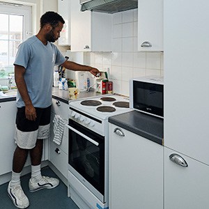 male student making tea in halls kitchen