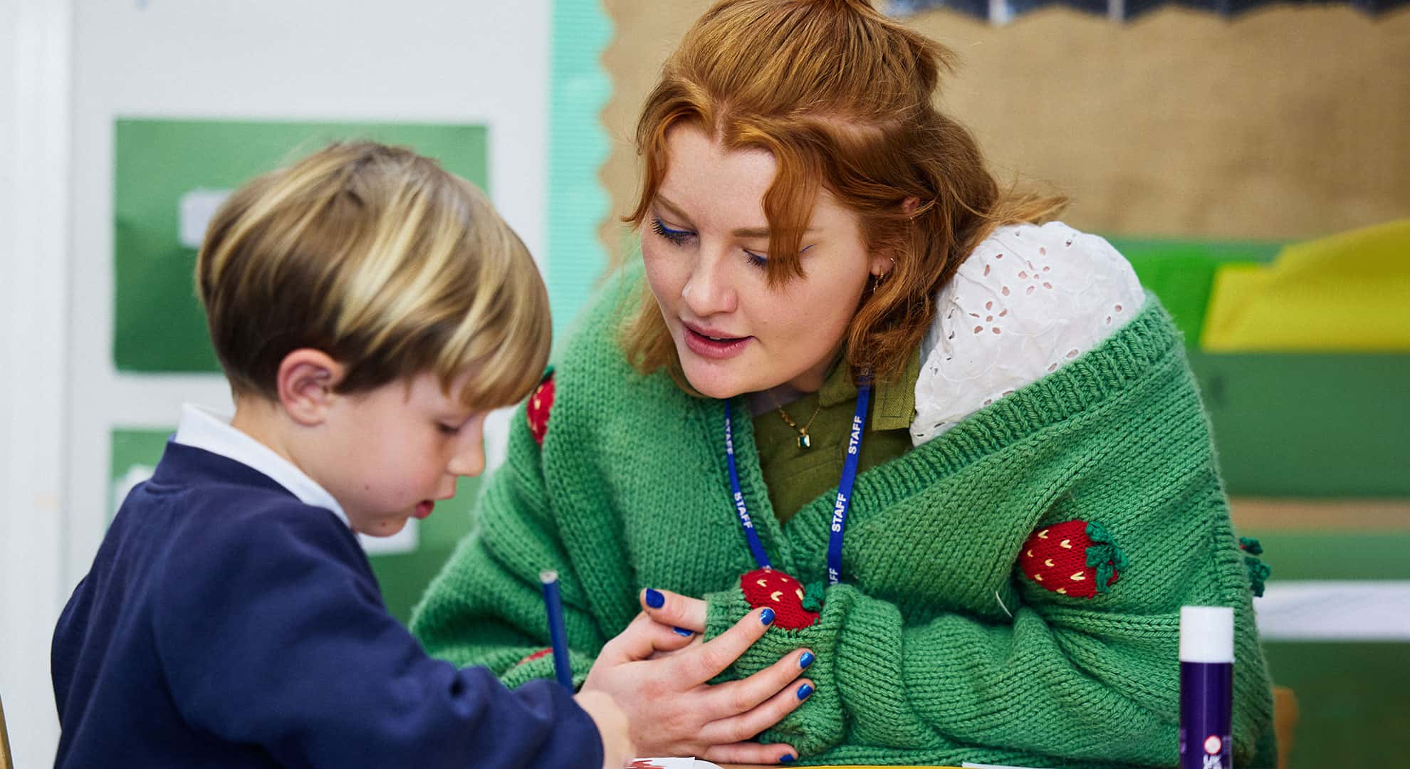PGCE student sat at a table with primary school student