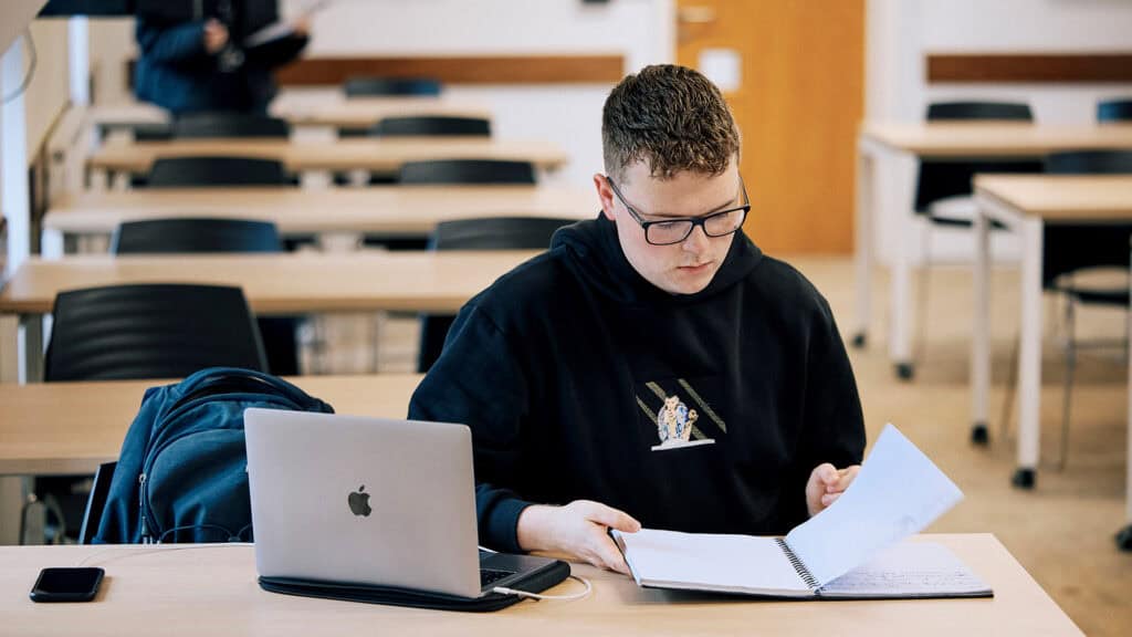 Business student reading notes in class