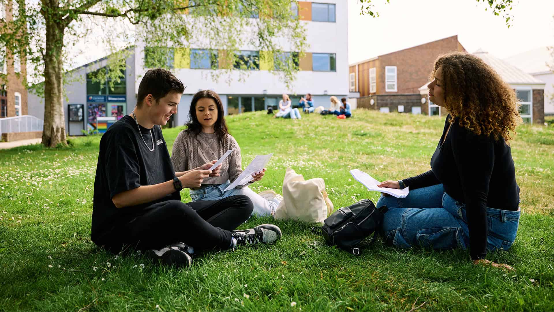 Group of students sat in University courtyard