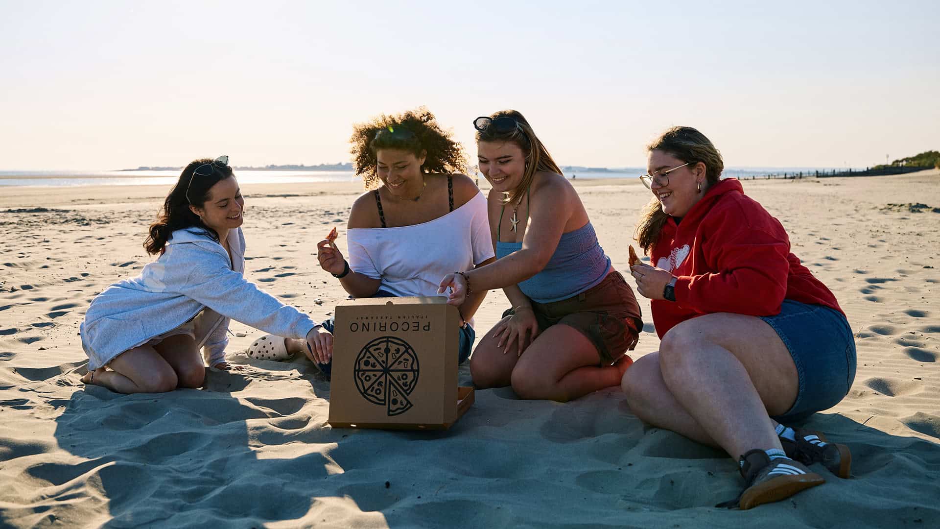 25 Pizza On The Beach (33) Students eating pizza on West Wittering Beach