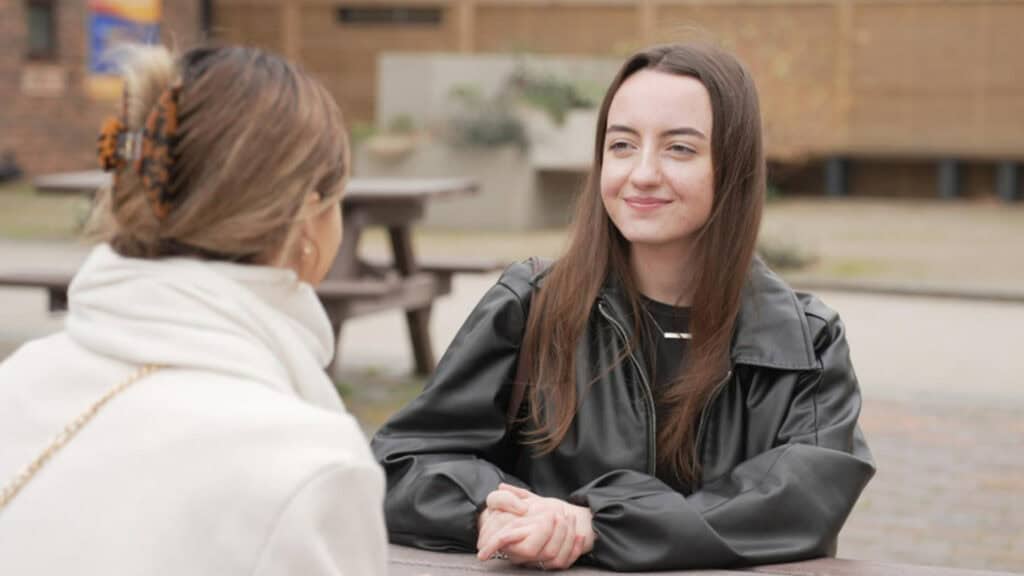 Two Sociology students sat talking in the University courtyard