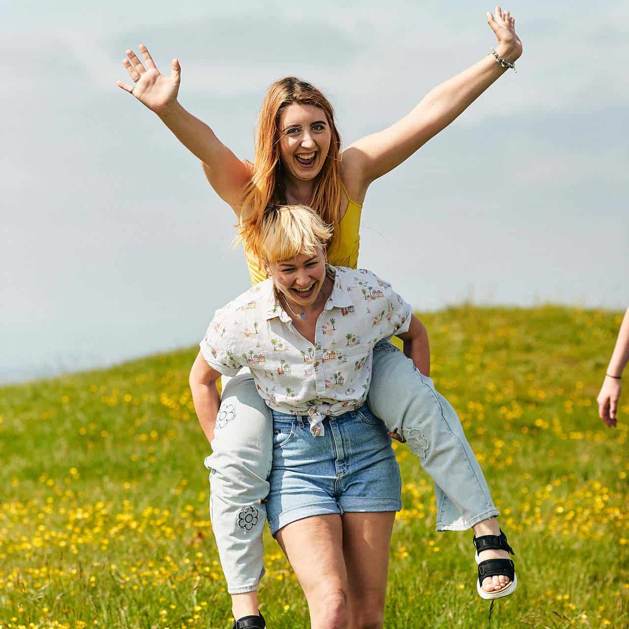 students having piggybacks on field in goodwood
