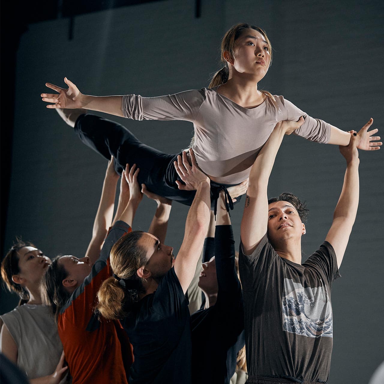 dance students rehearsing a routine holding a girl in the air