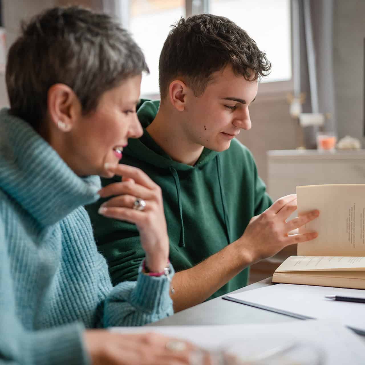 Student and parent sitting together reading