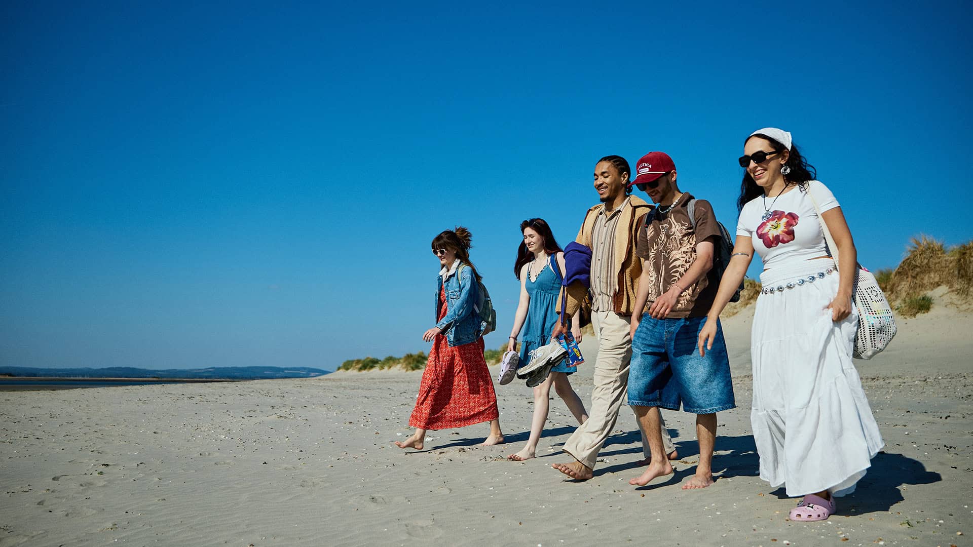 Group of students walking along West Wittering beach